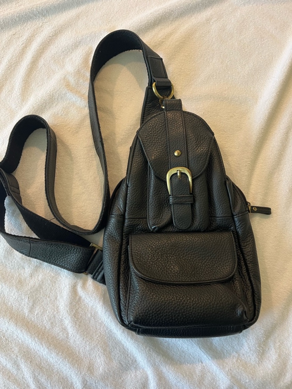 Black Leather Sling Backpack with Front Pocket and Buckle Detail